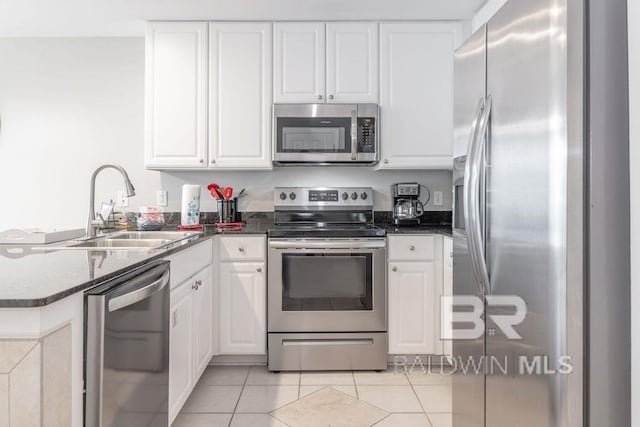 455 E Beach Blvd Unit 1505, Gulf Shores, AL 36542 - kitchen featuring a sink, light tile patterned floors, a peninsula, white cabinetry, and appliances with stainless steel finishes