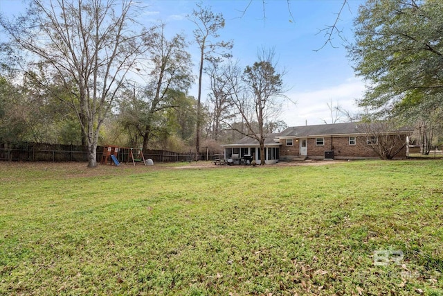 view of yard with a playground and a sunroom