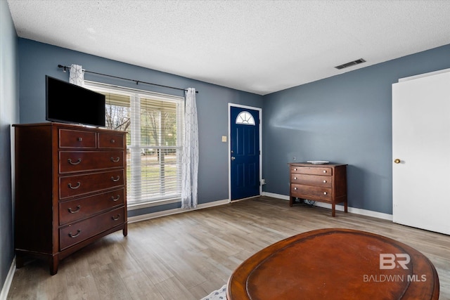 foyer with light hardwood / wood-style floors and a textured ceiling