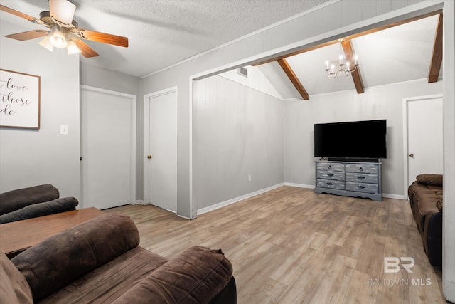 living room with hardwood / wood-style flooring, lofted ceiling with beams, a textured ceiling, and ceiling fan with notable chandelier