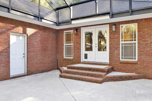 view of exterior entry with french doors and a patio area