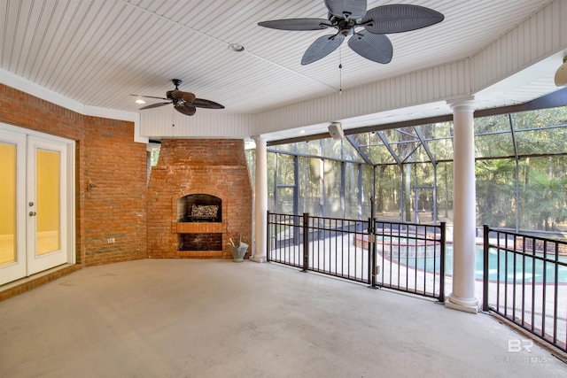 unfurnished sunroom featuring a fireplace and ceiling fan