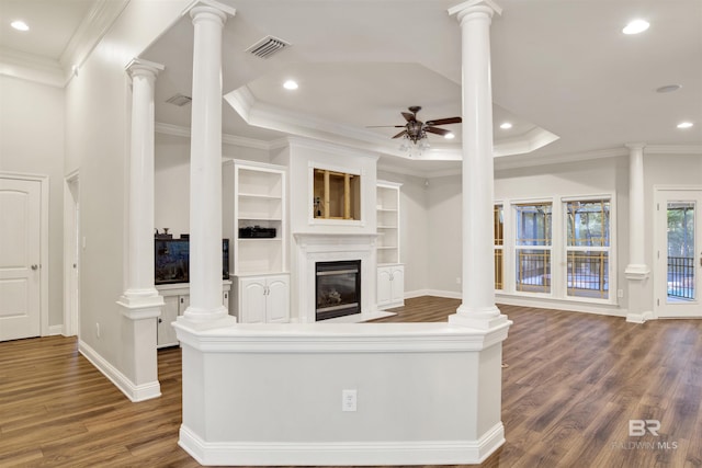 unfurnished living room featuring a tray ceiling, ceiling fan, and crown molding