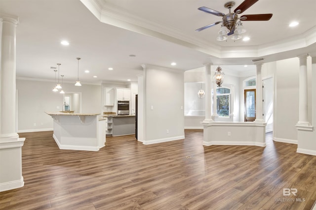 unfurnished living room featuring dark hardwood / wood-style floors, a raised ceiling, and ornamental molding