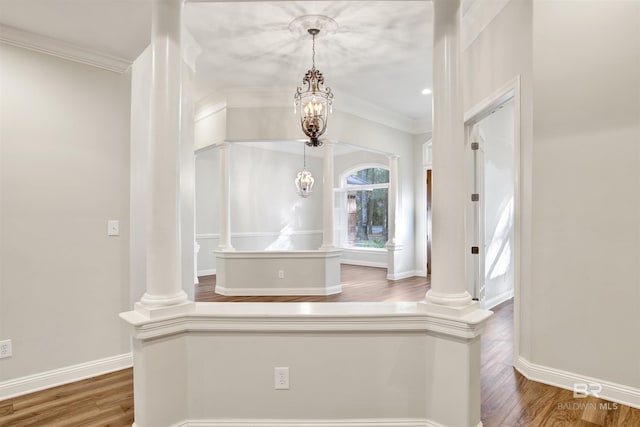 bathroom featuring ornamental molding, ornate columns, a notable chandelier, and wood-type flooring