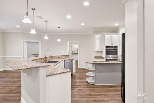 kitchen with pendant lighting, stainless steel appliances, white cabinetry, and sink