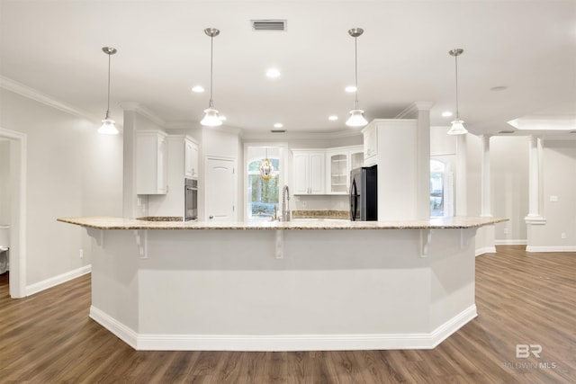 kitchen featuring pendant lighting, light stone counters, white cabinetry, and appliances with stainless steel finishes