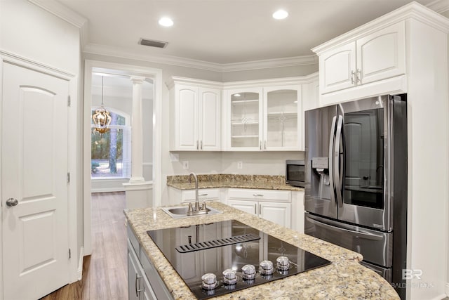 kitchen with decorative columns, white cabinetry, sink, and appliances with stainless steel finishes