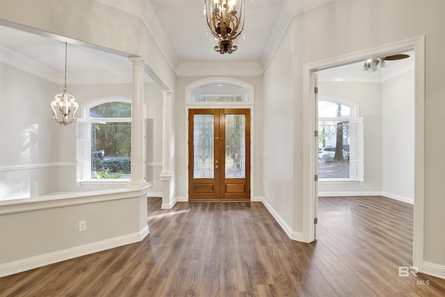 foyer featuring dark hardwood / wood-style floors, ornate columns, ornamental molding, and french doors