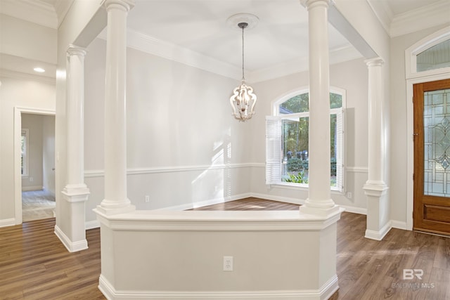 foyer entrance featuring dark hardwood / wood-style floors, crown molding, and a chandelier