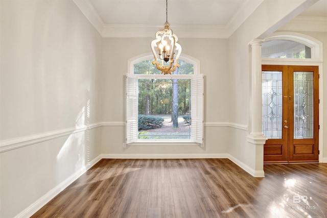 foyer featuring a chandelier, crown molding, dark wood-type flooring, and french doors