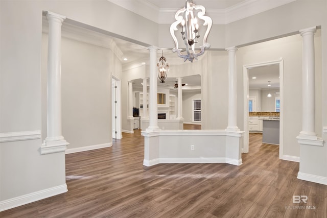 interior space featuring dark hardwood / wood-style floors, ornamental molding, and an inviting chandelier