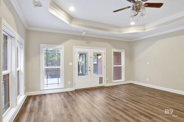 interior space with ceiling fan, french doors, crown molding, a tray ceiling, and hardwood / wood-style flooring