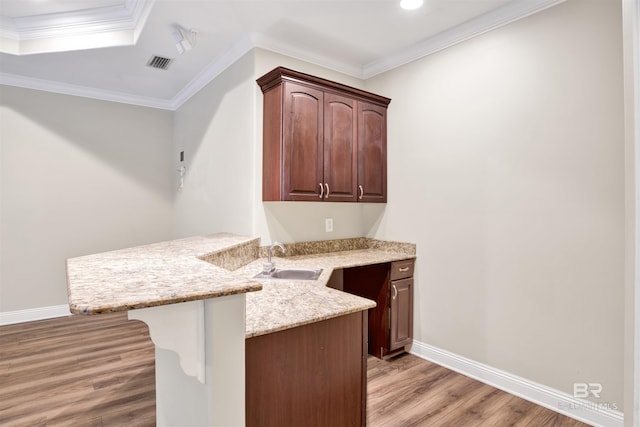 bar with light stone countertops, sink, light hardwood / wood-style flooring, crown molding, and dark brown cabinets