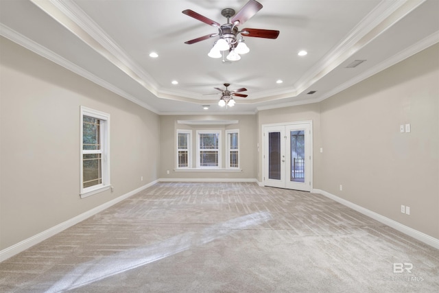 unfurnished room with a tray ceiling, ceiling fan, french doors, and ornamental molding