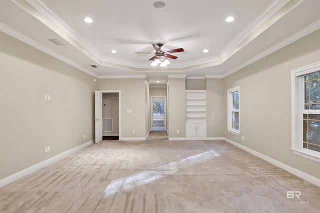 interior space featuring a tray ceiling, ceiling fan, ornamental molding, and light colored carpet