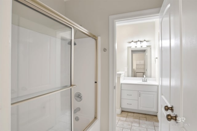 bathroom with combined bath / shower with glass door, vanity, and tile patterned flooring