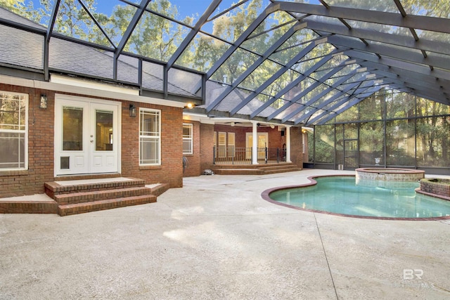 view of swimming pool with french doors, ceiling fan, a lanai, an in ground hot tub, and a patio