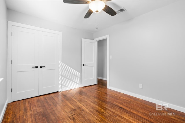 unfurnished bedroom featuring hardwood / wood-style floors, a closet, and ceiling fan