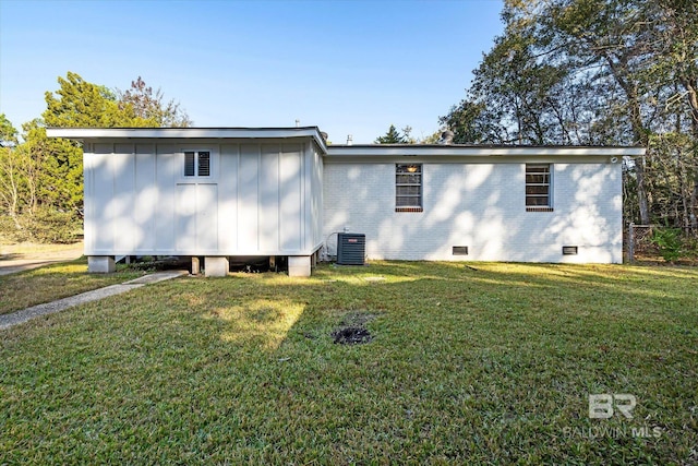 rear view of property featuring a yard and cooling unit