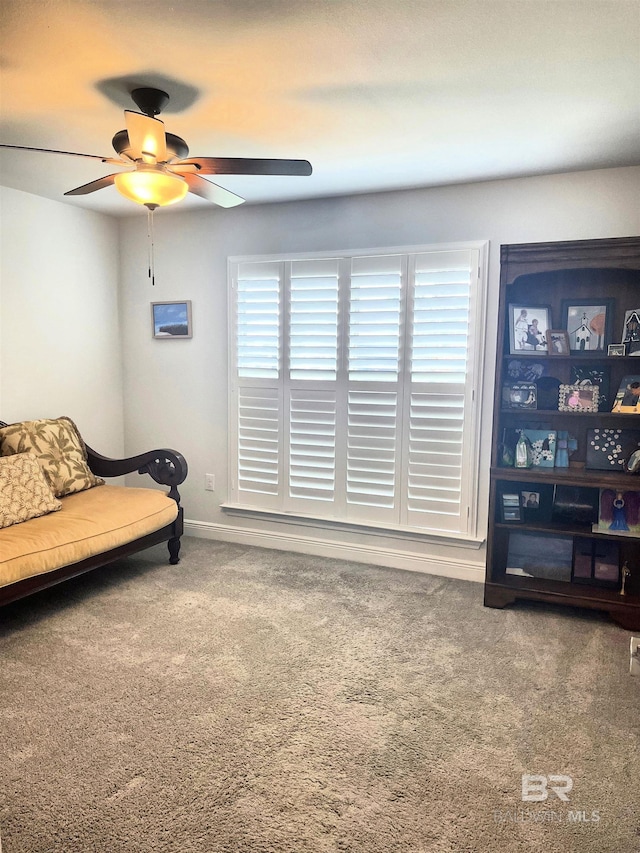 sitting room featuring a ceiling fan, carpet, and baseboards