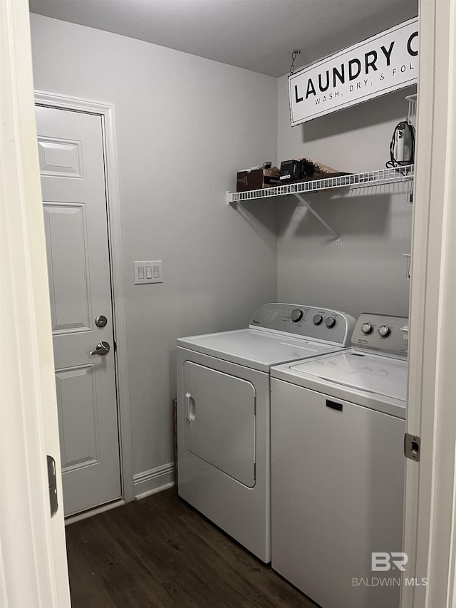 laundry area featuring washer and clothes dryer, laundry area, and dark wood-type flooring