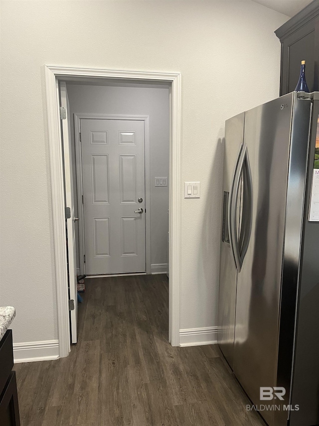 kitchen featuring baseboards, stainless steel refrigerator with ice dispenser, and dark wood-style flooring