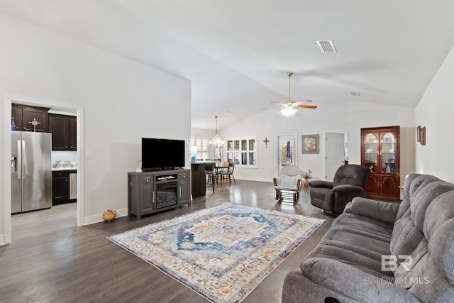 living area with dark wood finished floors, ceiling fan with notable chandelier, visible vents, and high vaulted ceiling