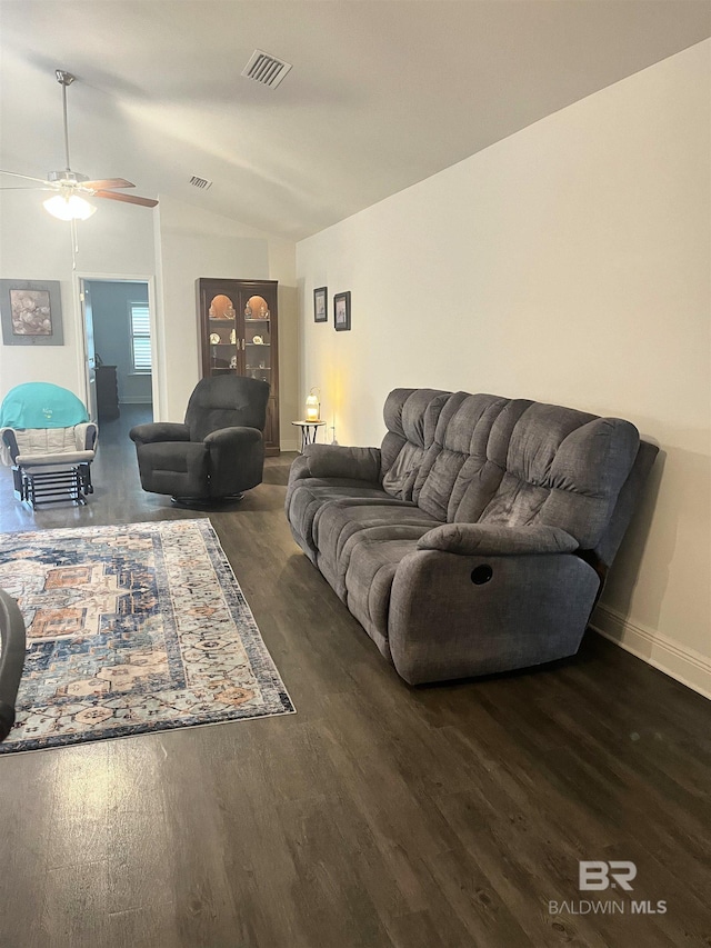 living area featuring visible vents, baseboards, lofted ceiling, and wood finished floors