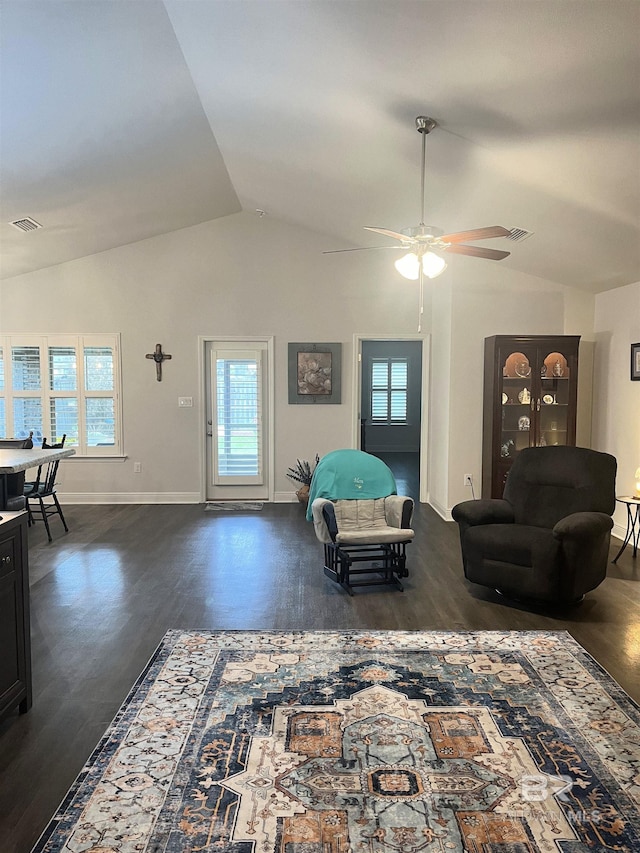 living room featuring dark wood finished floors, visible vents, baseboards, and vaulted ceiling