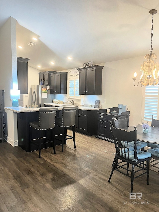 kitchen with a wealth of natural light, stainless steel fridge, light countertops, and dark wood-type flooring