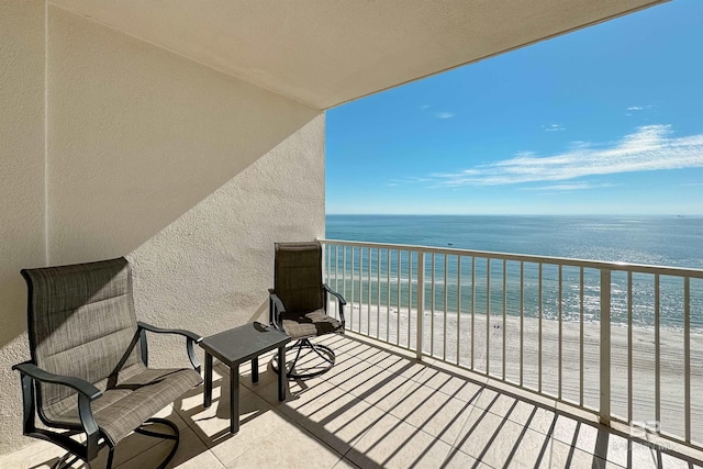 balcony with a water view and a beach view