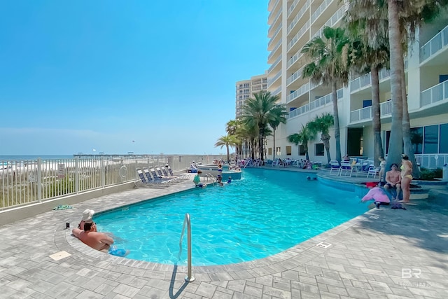 view of pool with a patio area and a water view