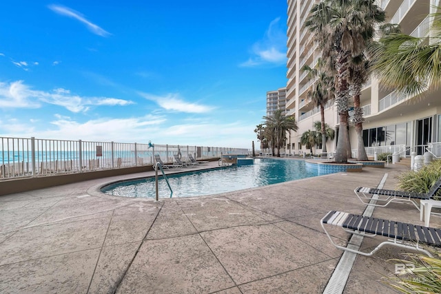 view of pool with a patio and a water view