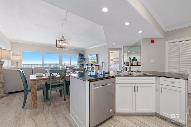 kitchen featuring white cabinetry, crown molding, stainless steel dishwasher, and light hardwood / wood-style floors