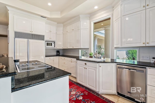 kitchen featuring white cabinets, built in appliances, and sink