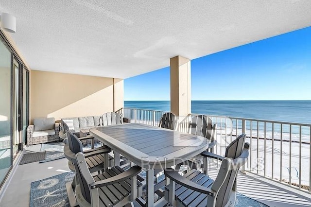 balcony with a water view and a beach view