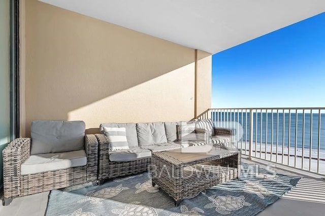 balcony with a water view and a view of the beach