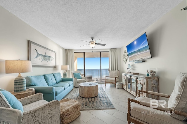 living room with ceiling fan, floor to ceiling windows, a textured ceiling, and light tile patterned floors