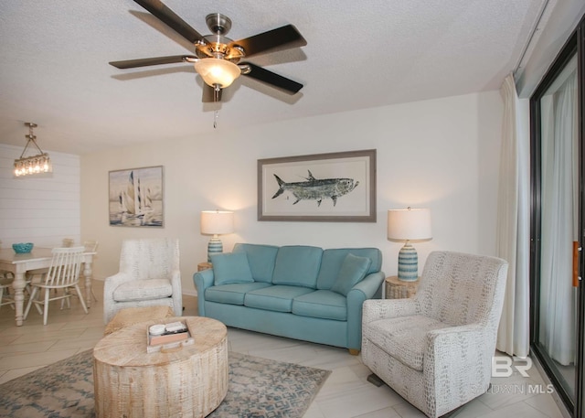 living room with ceiling fan and a textured ceiling