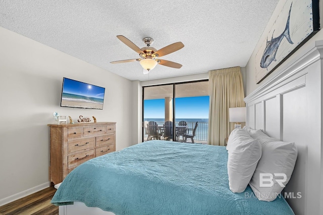 bedroom featuring ceiling fan, dark wood-type flooring, access to outside, and a textured ceiling