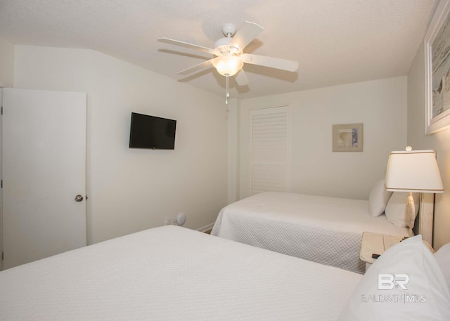 bedroom featuring a textured ceiling, ceiling fan, and a closet