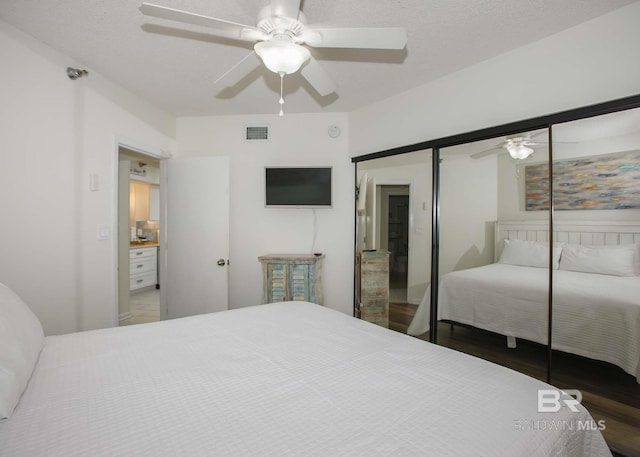 bedroom with ceiling fan, dark hardwood / wood-style flooring, a closet, and a textured ceiling