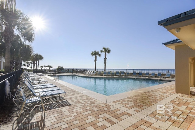 view of swimming pool with a patio and a water view