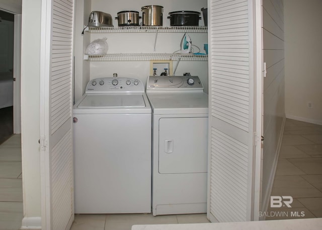 laundry room with separate washer and dryer and light tile patterned floors