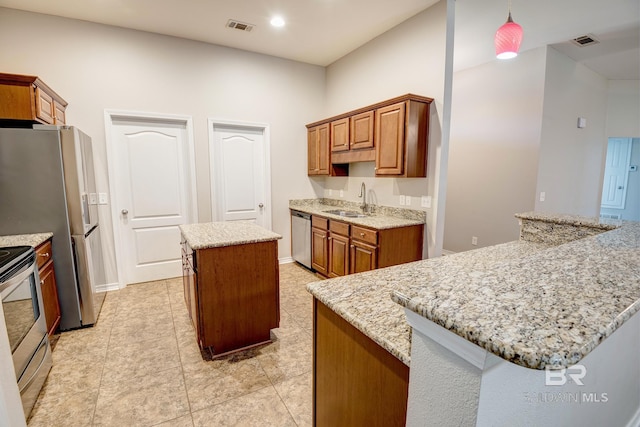 kitchen featuring light tile patterned flooring, sink, light stone countertops, appliances with stainless steel finishes, and a kitchen island