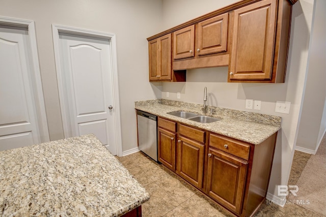 kitchen with stainless steel dishwasher, light tile patterned flooring, light stone counters, and sink