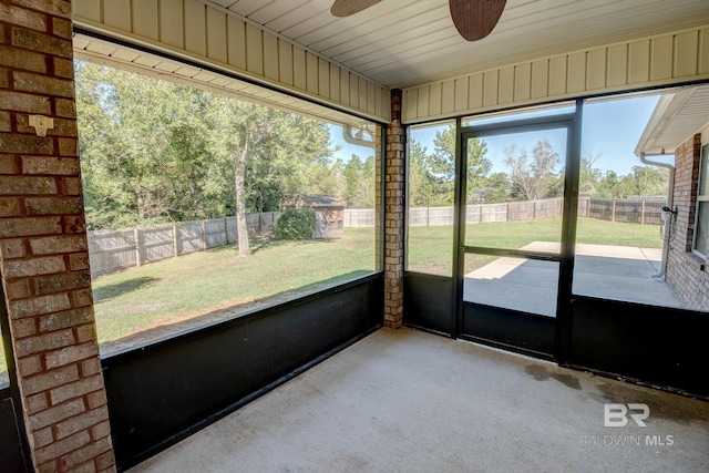 unfurnished sunroom featuring ceiling fan