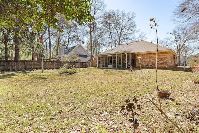 view of yard featuring a fenced backyard and a sunroom