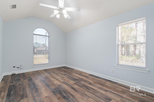 spare room with a ceiling fan, baseboards, visible vents, dark wood finished floors, and vaulted ceiling